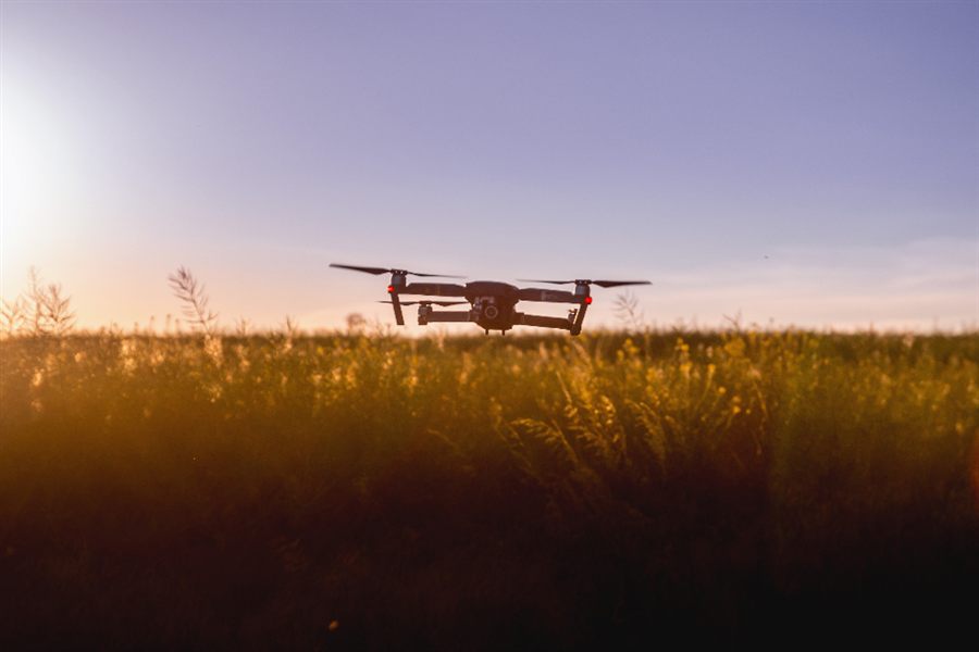 Dron sobrevolando un cultivo al atardecer — tecnología para el agro